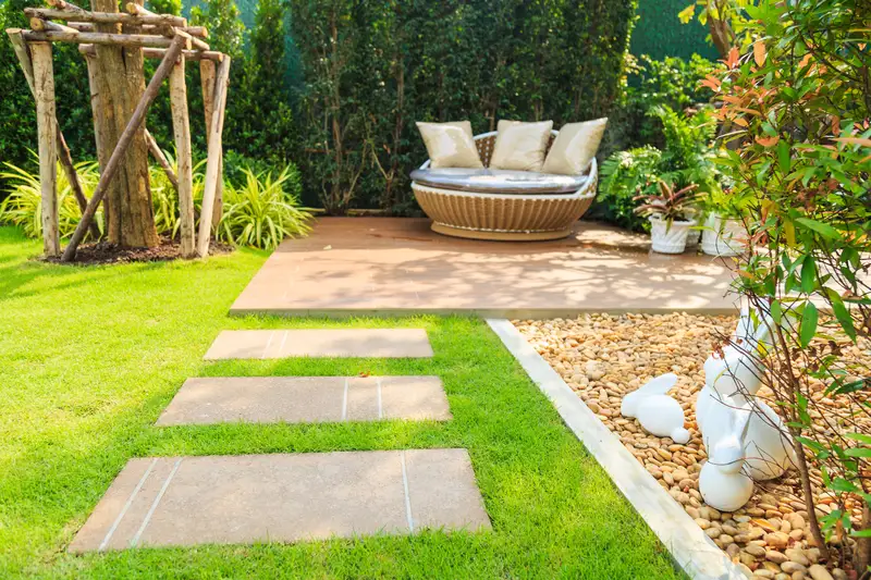 Backyard deck with circular lounge chair and stone pavers in lawn