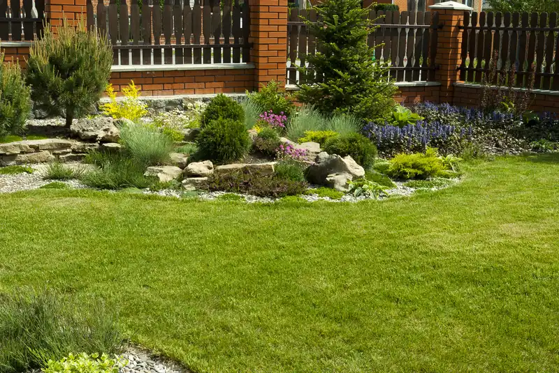 Backyard rock garden landscaping with decorative shrubs and fence. Backyard rock garden landscaping with decorative shrubs and fence.