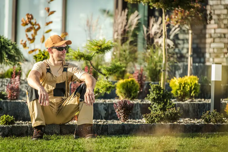 Professional landscaper sitting in a newly designed residential garden
