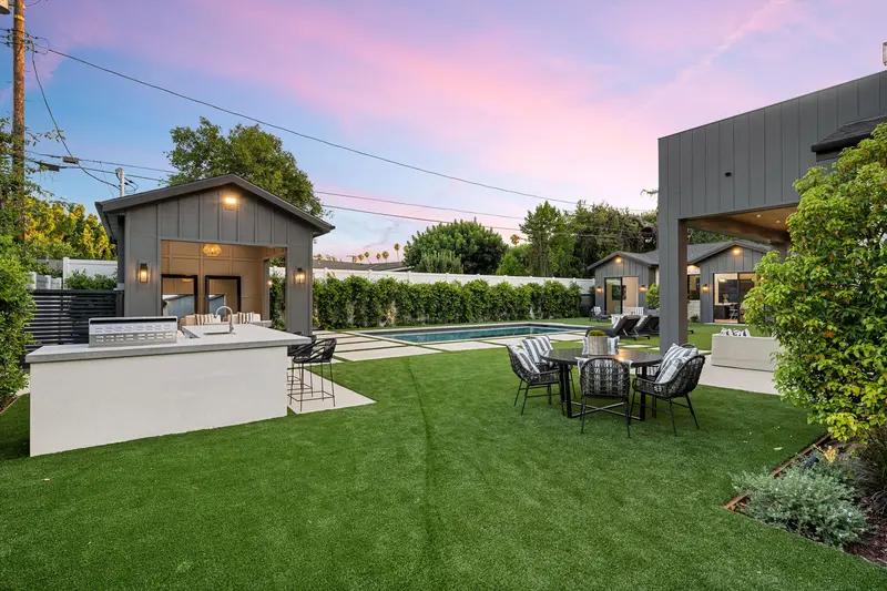 Luxurious backyard remodel with artificial turf, dining table, and swimming pool. Luxurious backyard remodel with artificial turf, dining table, and swimming pool.